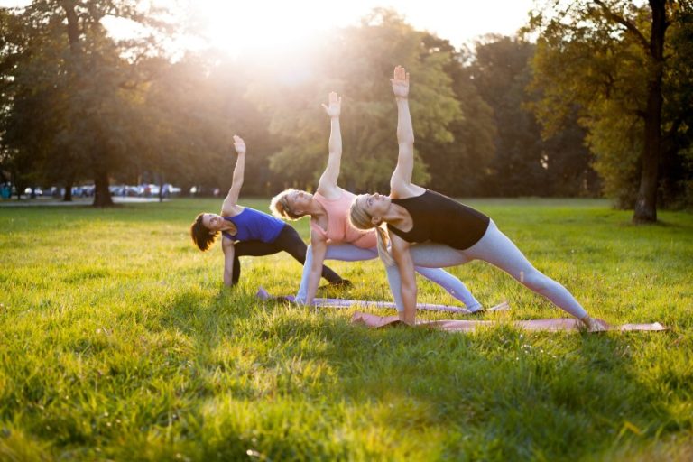 Séance de yoga en plein air dans un parc verdoyant au printemps, sous un ciel clair et lumineux