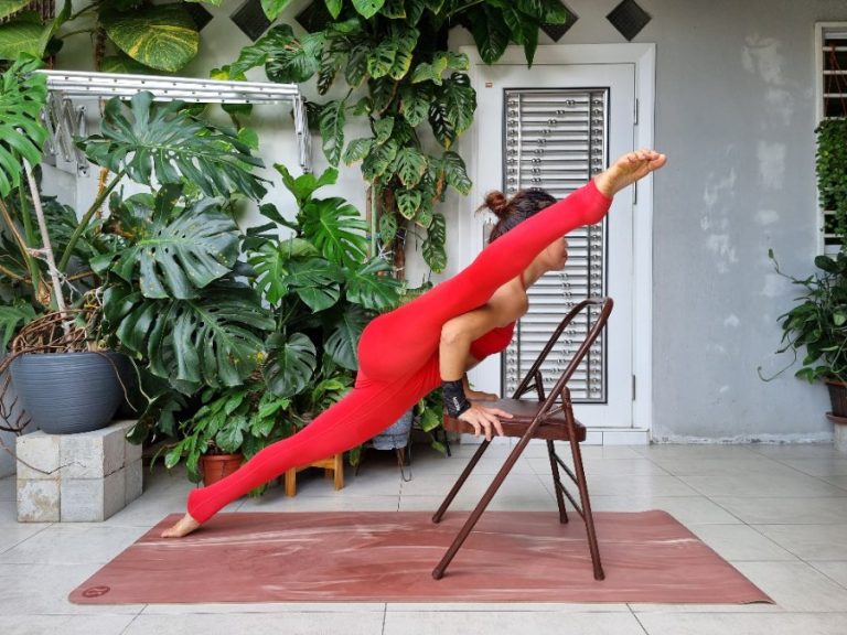 Une personne pratique des postures de yoga assis guidée par son téléphone