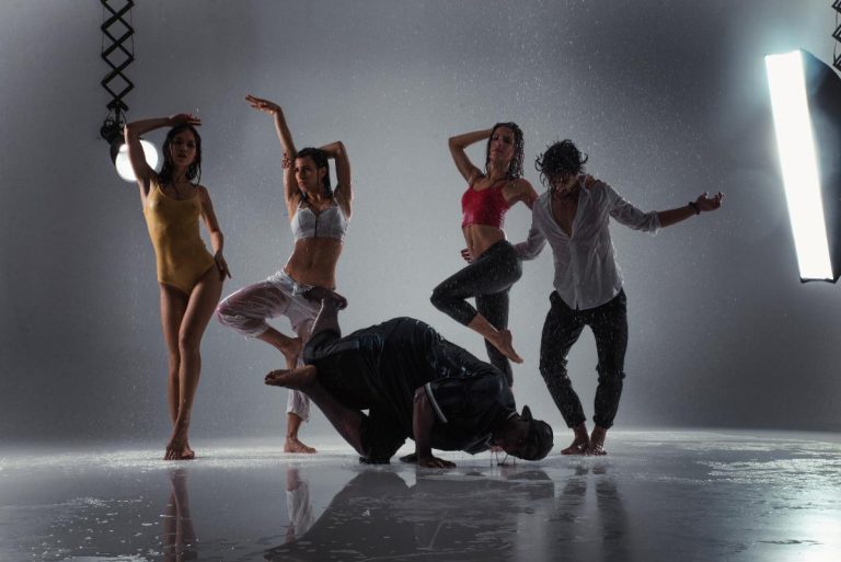Danseur seul effectue un mouvement fluide au milieu d’un studio baigné de lumière naturelle