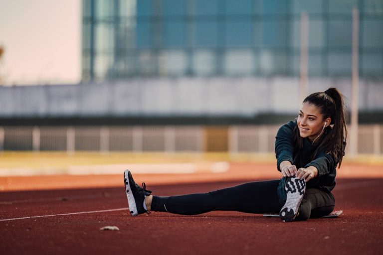 Une fille sportive faisant des étirements après son sport pour éviter la courbature