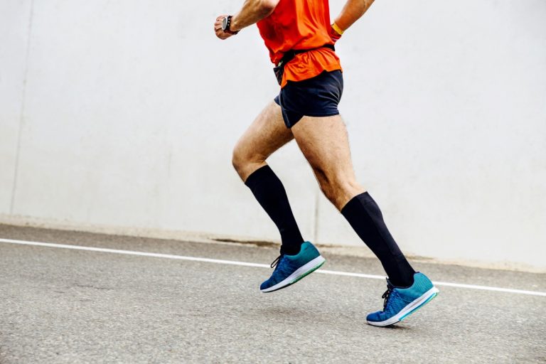 Un sportif qui met un bas de contention pendant ses activités