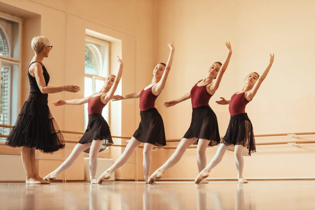 Une professeur apprenant de la danse à un petit groupe de filles 