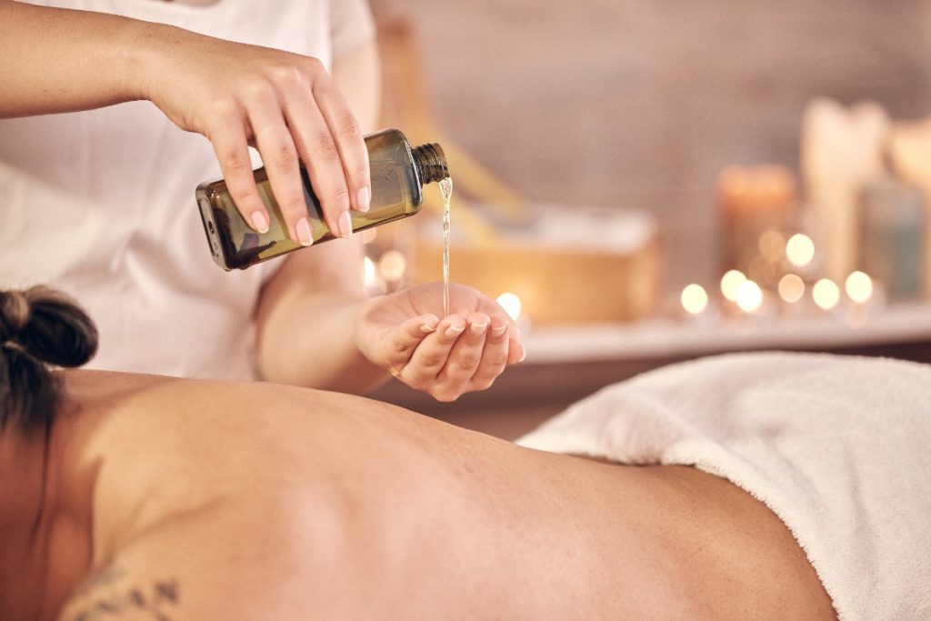 Une femme qui reçoit un massage avec de l'huile essentielle