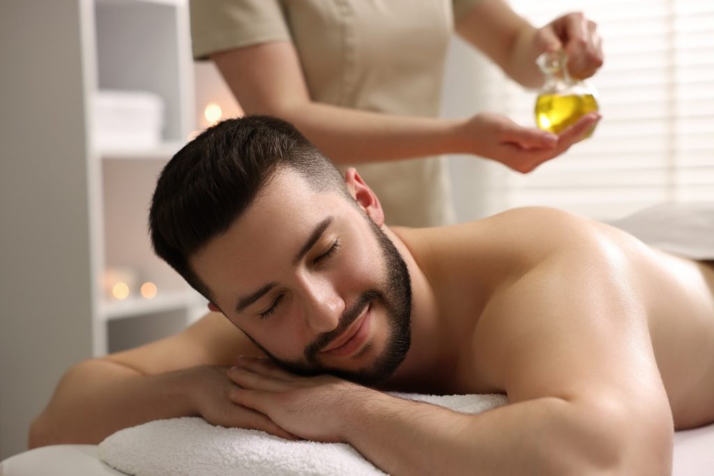 Un homme recevant un massage relaxant avec de l'huile essentielle