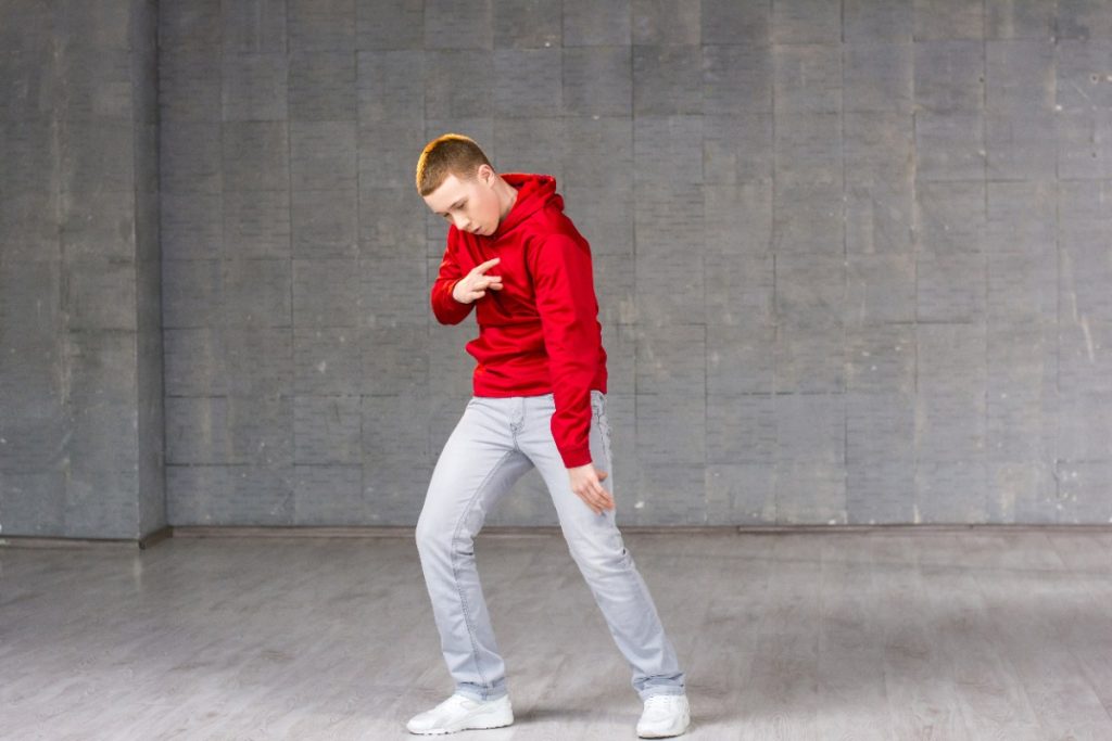 Un homme en sweat rouge qui danse le twist