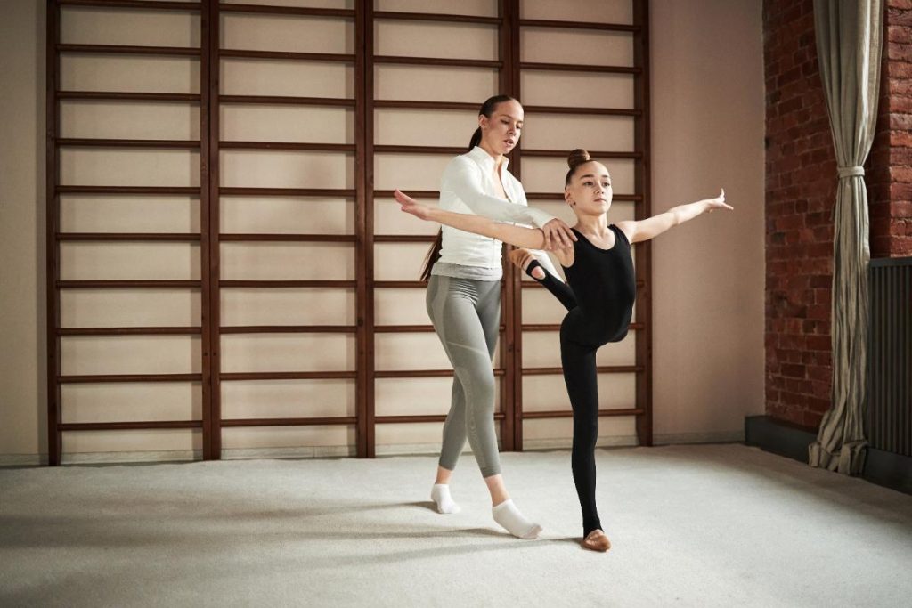 Instructeur aidant une jeune danseuse 