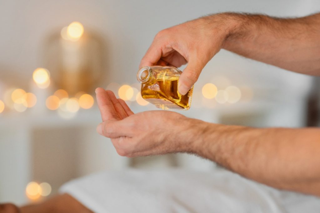 Une personne qui verse de l'huile essentielle pour un massage