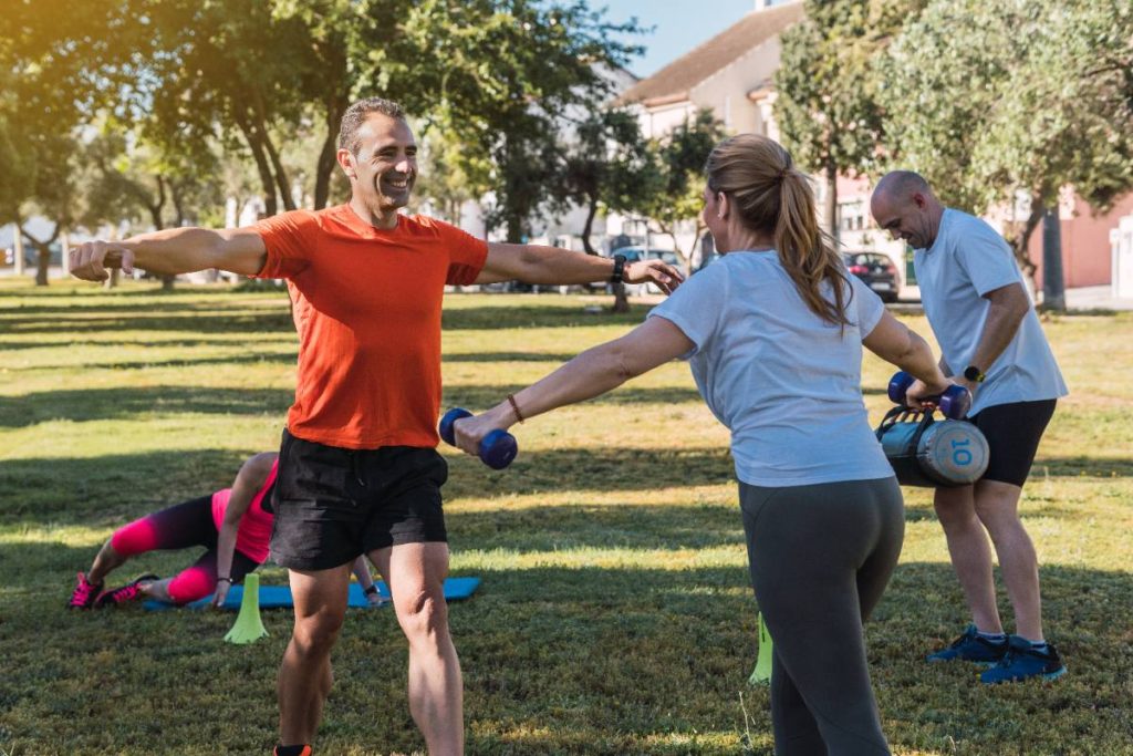 Des adultes s'exerçant avec des poids à l'extérieur