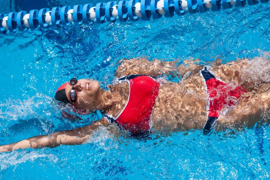 Une femme en bikini rouge nageant dans la piscine