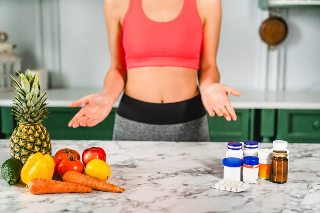 Une femme en forme avec des aliments sains sur la table