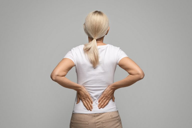 Une femme massant ses muscles en bas du dos