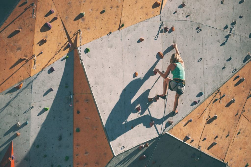 Une femme qui pratique de l'escalade sur le mur