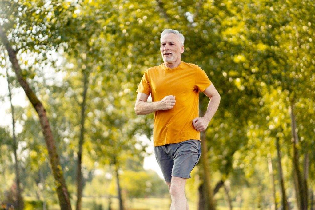 Un homme senior appréciant courir dans le parc