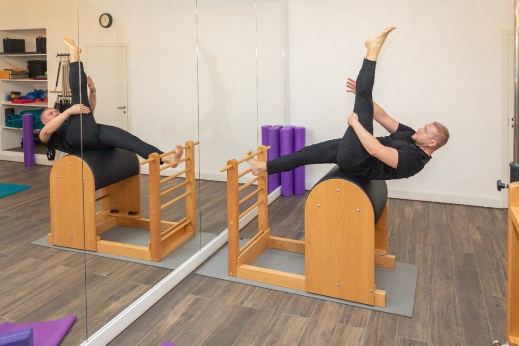 Un homme en tenue noire qui s'étire avec un appareil de pilates