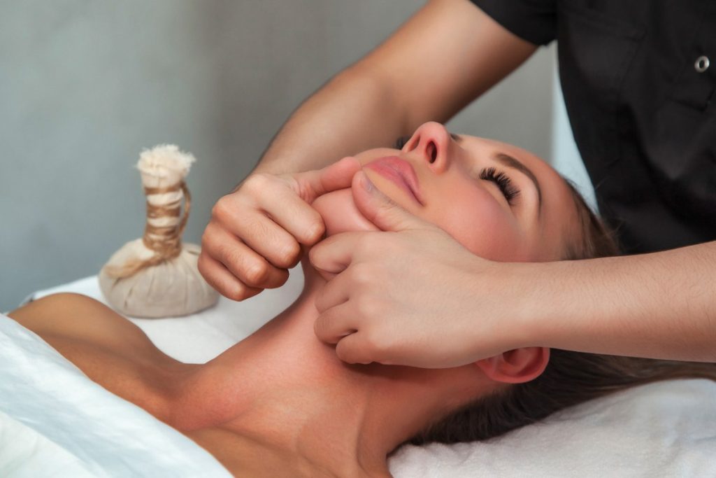 Une femme se relaxant pendant son massage facial
