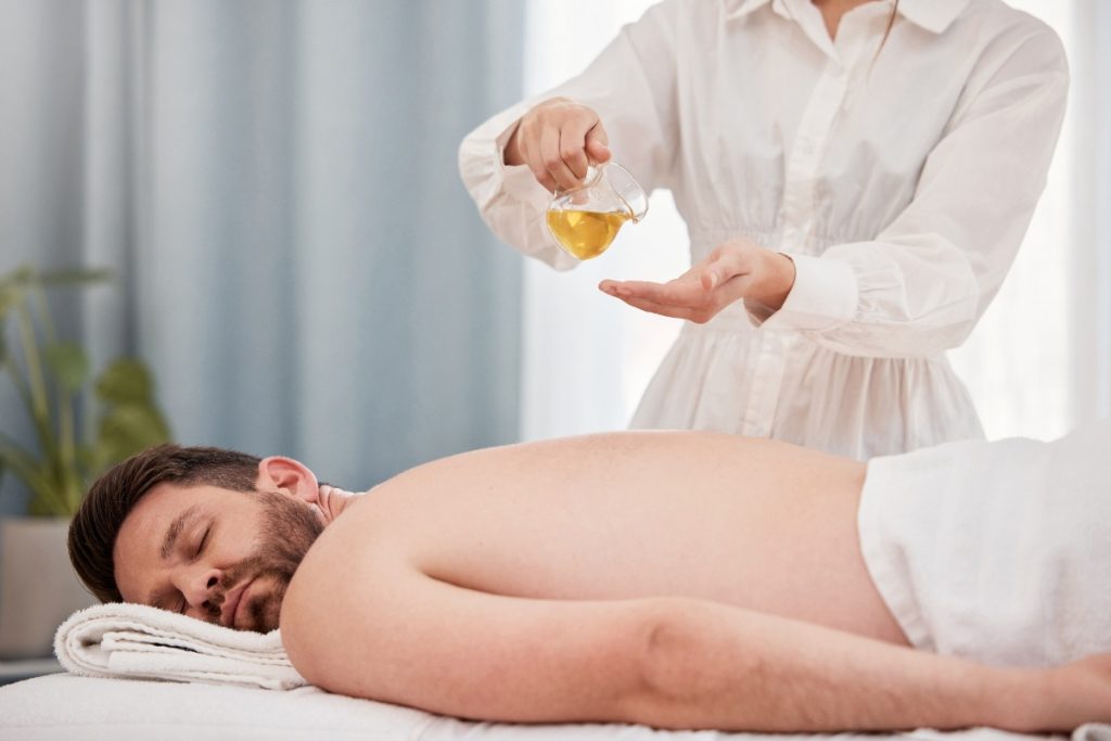Un homme recevant un massage avec de l'huile essentielle